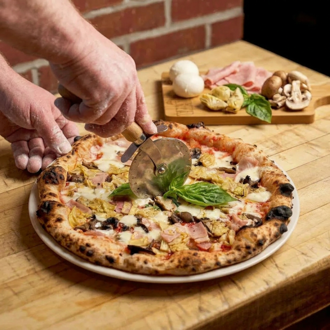 Capricciosa pizza being cut with a pizza wheel